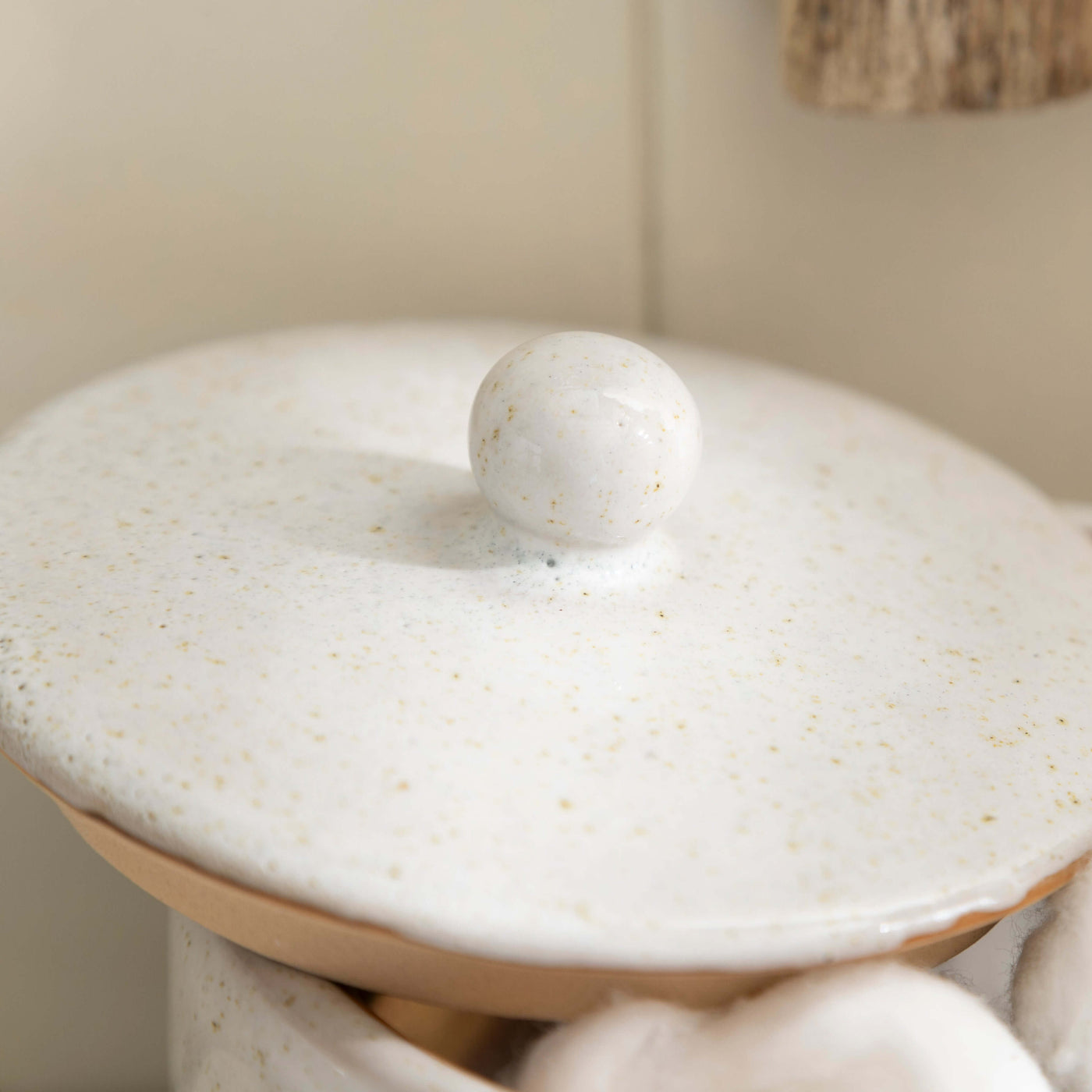 Stone effect ceramic lidded jar from bathroom accessory set with textured finish.