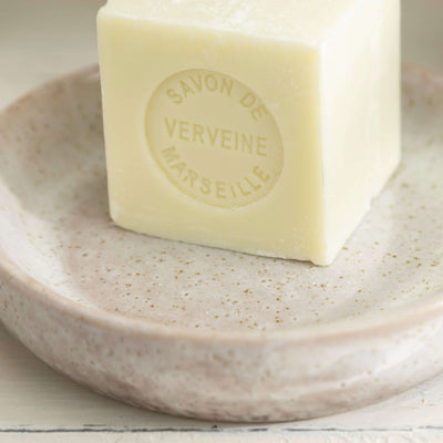 Stone effect ceramic soap dish with a bar of verbena Marseille soap placed on top, showcasing natural elegance and texture.